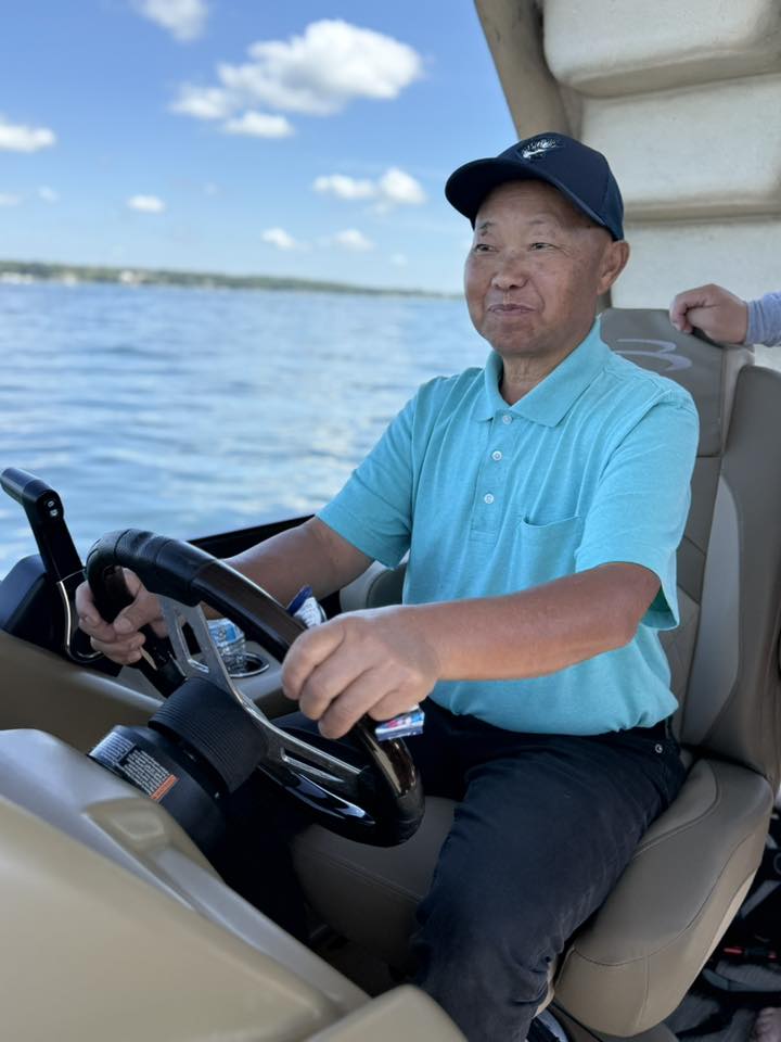 Brother in patterned shirt seated on the pontoon
